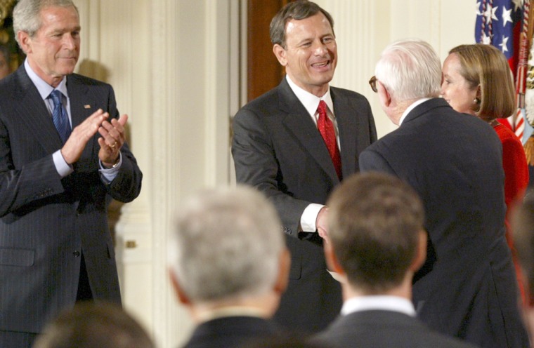 John Roberts shakes hands with Supreme Court Justice John Paul Stevens on Thursday, after Roberts was sworn in as chief justice.