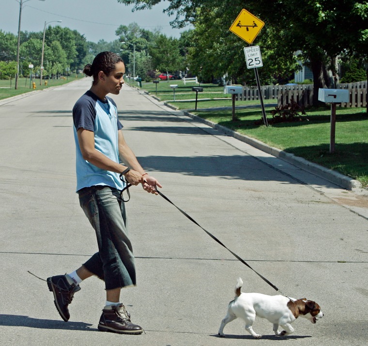 ** ADVANCE FOR SUNDAY, OCT. 2 **Alex Polanco walks his dog Clide along a quiet Neenah, Wis., street near his apartment on Aug. 1, 2005. Polanco exists in a gray area, where gender is often blurred and where he feels no obligation to choose one gender over the other. He often switches back and forth around friends he trusts or in urban neighborhoods where he feels free to express himself. (AP Photo/Morry Gash)