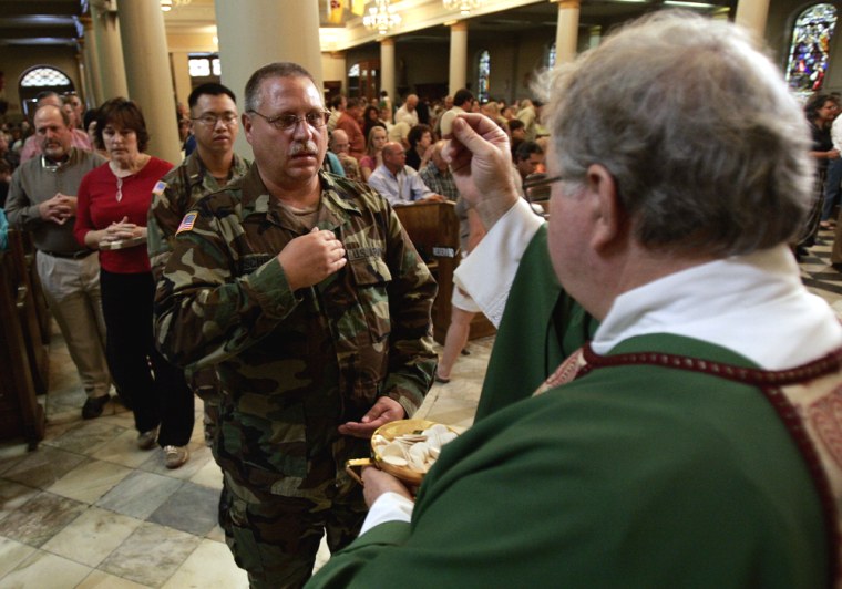A National Guardsman receives communion during the first Mass at the historic St. Louis Cathedral since Hurricane Katrina hit more than a month ago, Sunday, Oct. 2, 2005, in New Orleans. (AP Photo/Kevork Djansezian)