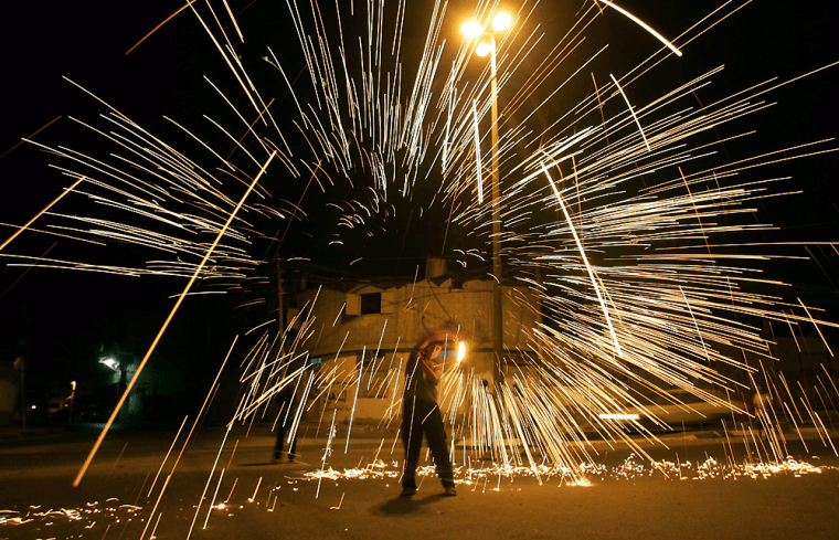 A Palestinian boy holds a homemade sparkler after breaking the fast on the first day of Ramadan in Gaza City on Tuesday.
