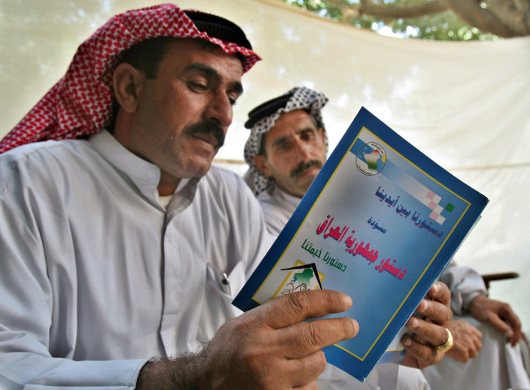 Iraqis read a draft of the country's constitution in Baghdad on Wednesday.