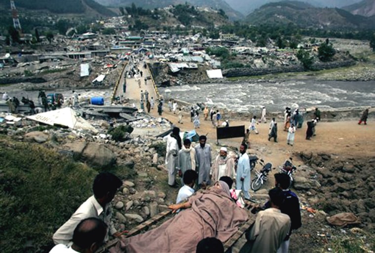 An injured Pakistani earthquake survivor is carried from the rubble of a building in Balakot, Pakistan Tuesday, Oct. 11, 2005. (AP Photo/David Guttenfelder)