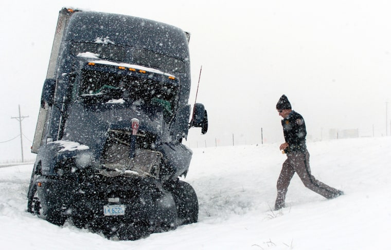 A Colorado Highway Patrol officer checks on a truck stuck on Interstate 70 Monday in Aurora.