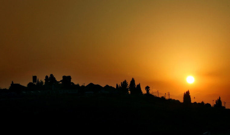The sun sets over the hilltop Jewish settlement of Sanur near the West Bank city of Jenin, Monday, Aug. 22, 2005. Settlers camped out in Sanur and the nearby settlement of Homesh are expected to put up fierce, and possibly violent, resistance to troops scheduled to evacuate both hilltop settlements Wednesday. (AP Photo/Nasser Nasser)