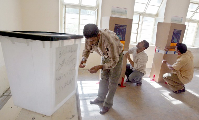 Iraqi voting station employees install elections material at a voting station in Basra