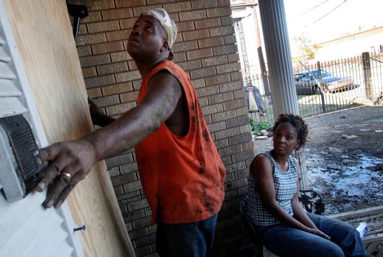Dennis Rowan Sr., left, and Antoinette Rowan, put a piece of plywood over the door to Antoinette's aunt's home in New Orleans' Ninth Ward on Oct. 8 after looking at the destroyed inside.