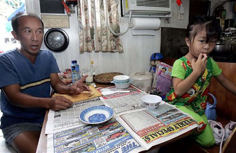 Tam Tran, a fisherman, complains about the levels of paperwork and difficulty he has to get any sort of Hurricane Katrina assistance, while his daughter Vanna, 4, plays in their Biloxi, Miss., fishing boat, Oct. 7, 2005. The vessel, is too small to make a fishing trip to the Texas waters that are mostly unpolluted, and since Tran's home was destroyed by Katrina, the boat now serves as a home for Tran, pregnant wife and daughter. Tran argues that FEMA should be better organized and more localized to deal with the fishermen, since most have lost their homes and cars and find transportation to one of the help centers difficult to obtain. (AP Photo/Rogelio Solis)