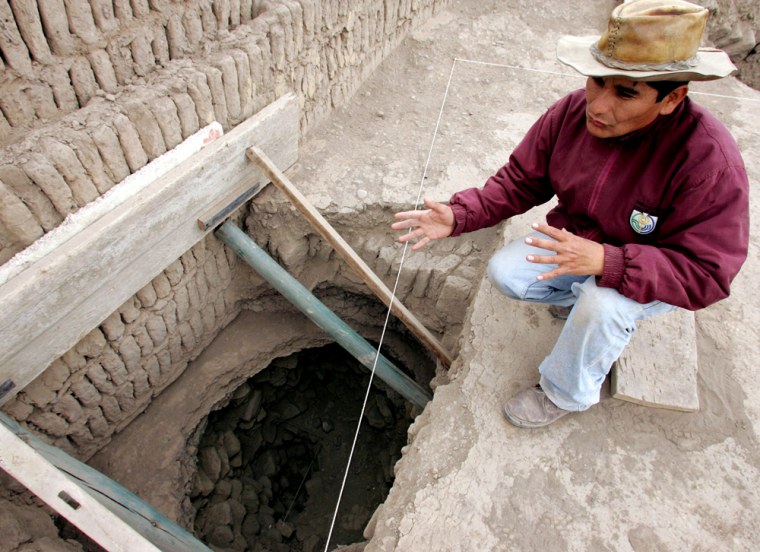 Peruvian archaeologist Ccencho shows the hole where the mummy was buried in Lima's Huaca Pucllana ceremonial complex