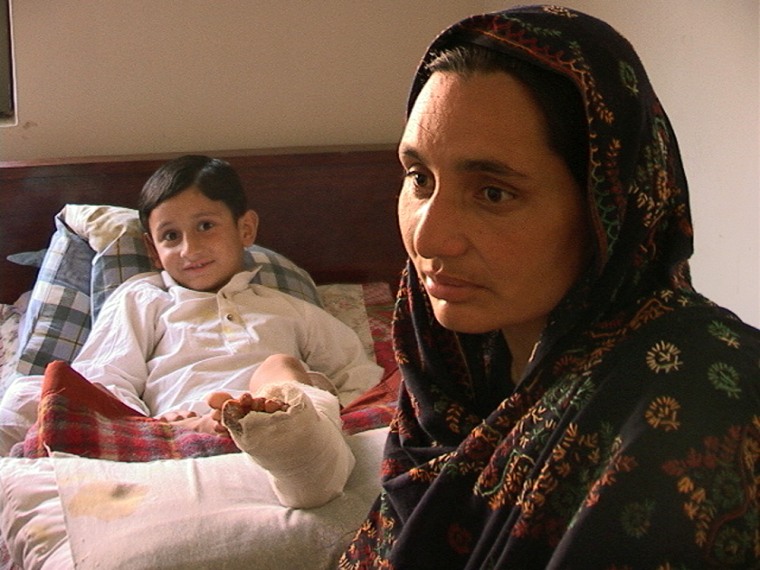 Zein Manzoor, 6, sits with his mother, Nargiz Manzoor, while he recovers from the broken leg he got when his school collapsed in the Oct. 8 earthquake.