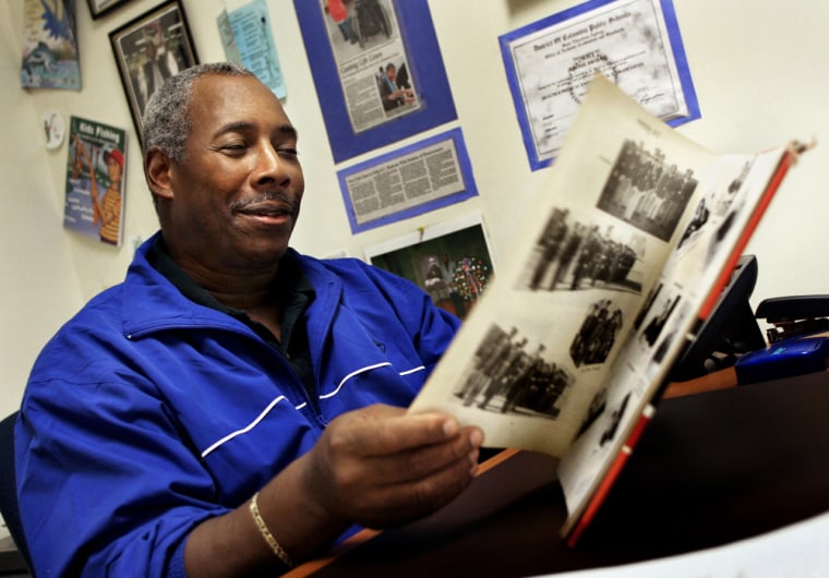 Jerome Brocks, shown here looking over his 1969 Dunbar H.S. yearbook that featured him when he was a Lt. Col. in the 1st Regiment Military Cadet Corps, is against the military calling his family at home to recruit his daughter.