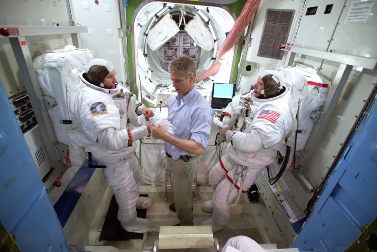 Expedition 12 astronauts Valery Tokarev, left, and Bill McArthur, right, participate in a spacewalk training session in June at NASA's Johnson Space Center, aided by German astronaut Thomas Reiter. The session helped Tokarev and McArthur prepare for next week's spacewalk on the international space station.
