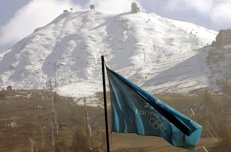A Winter 2006 Olympic flag waves in front of the Alpine Ski Giant Slalom course in Sestriere, Italy, on Oct. 13, 2005.