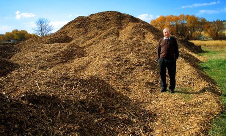 Murray Dalgleish, superintendent of the the Council School District in Idao, stands with a pile of biomass chips used to fuel school furnaces.