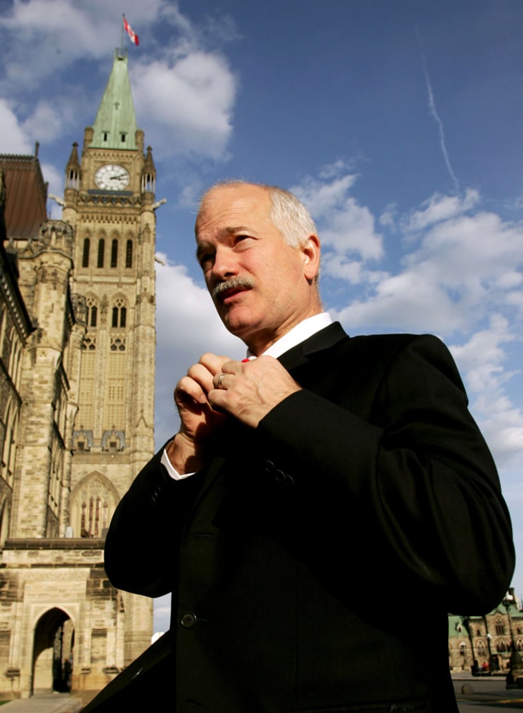 New Democratic Party leader Layton adjusts his poppy on Parliament Hill in Ottawa