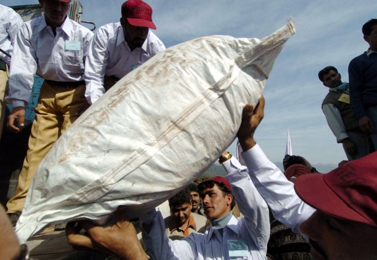 Pakistani porters load tents provided by