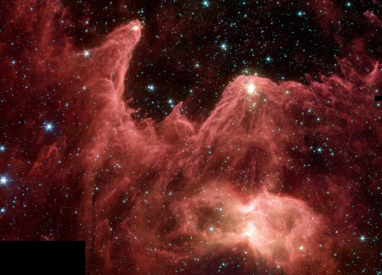 The Spitzer Space Telescope's infrared view of the "Mountains of Creation," or W5, reveals clouds of dust and gas lit up by protostars within. The view isn't nearly as dramatic in visible wavelengths because the clouds block the light coming from the embryonic stars.