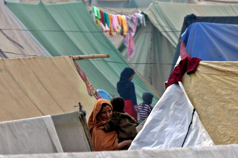Kashmiri earthquake survivors start a day at a makeshift tent camp in Muzaffarabad