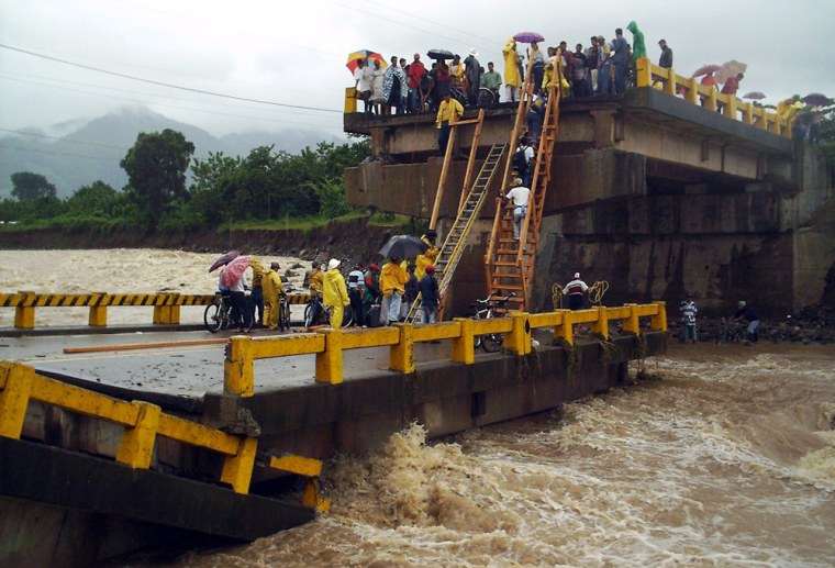 Residents try to cross a  bridge over the Monga river in Saba, northern Honduras,  which collapsed  because of the heavy rains  Nov. 18, 2005. Tropical Storm Gamma formed Friday off the coast of Honduras, the 24th named storm of an already record-breaking Atlantic hurricane season. Gamma was expected to sweep along the coasts of Honduras, Belize and Mexico's southern Yucatan peninsula this weekend before heading toward Cuba's western tip and then  to southern Florida. (AP Photo/Diario el Tiempo)