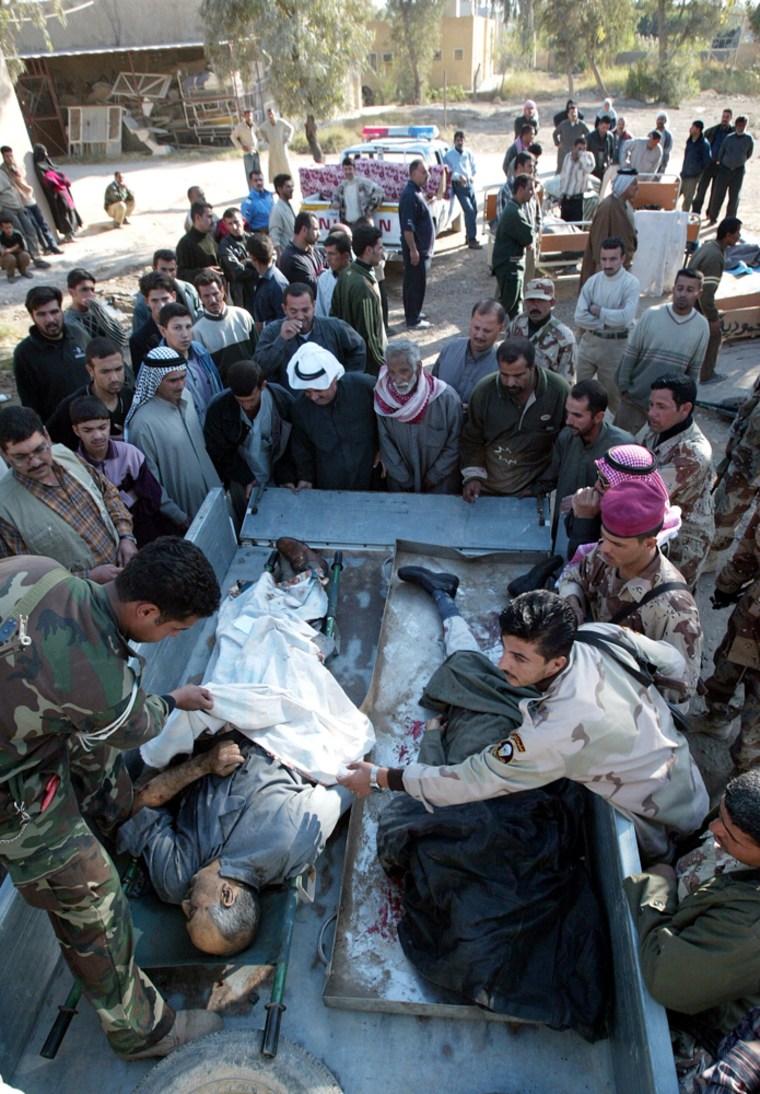 The bodies of people killed in a suicide car bombing Thursday are transported to the hospital in Mahmoudiya, Iraq.