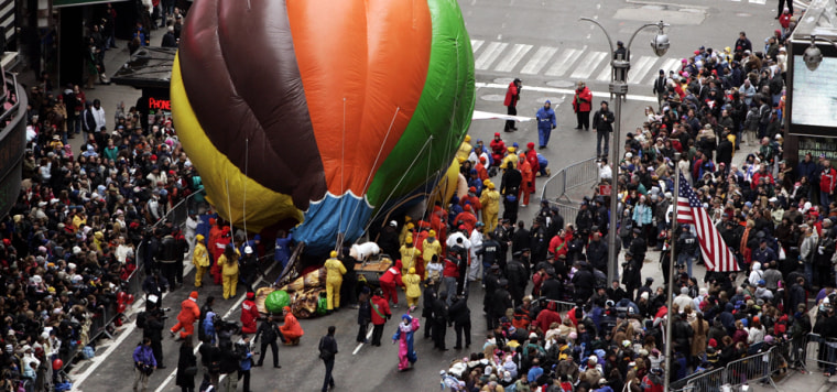 A balloon lies on the street after it hit a light pole, showering debris on two people during the Macy's Thanksgiving Day parade in New York.
