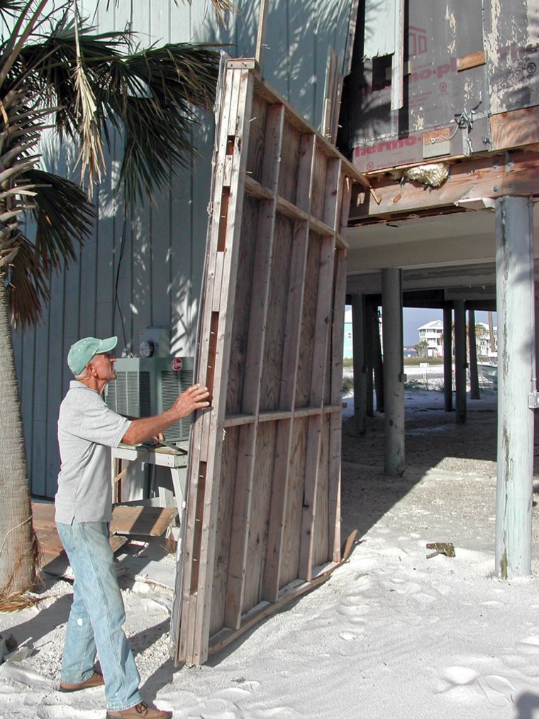 Gene Hudkins works to repair his beach house at Navarre Beach on Santa Rosa Island, Fla., in November. The bottom floor, where he had his workshop, has been wrecked three times since he built the house in 1994.