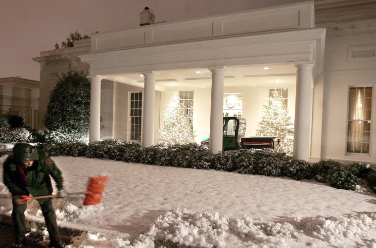 National Park Service workers get an early start, Friday, Dec. 9, 2005, on clearing the snow in front of the West Wing of the White House that fell overnight. The Washington area got a mix of snow, sleet and rain from the storm that is moving up the coast. (AP Photo/Ron Edmonds)