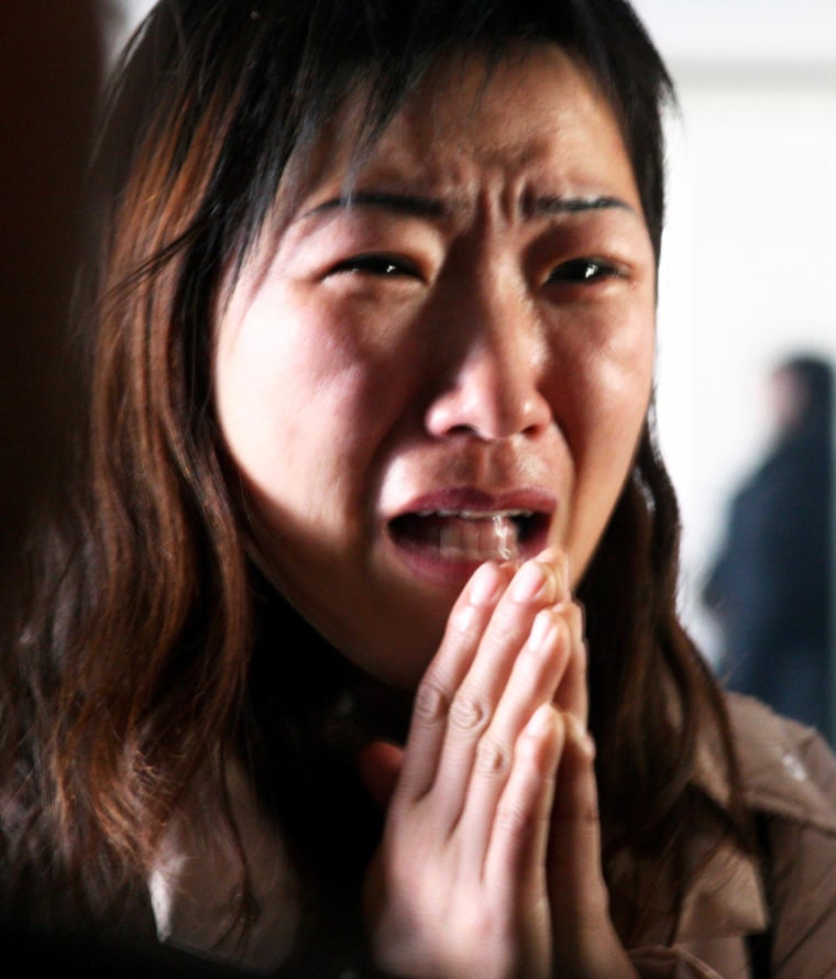Chinese woman cries as she looks for her relative missing in a fire at Central Hospital in Liaoyuan