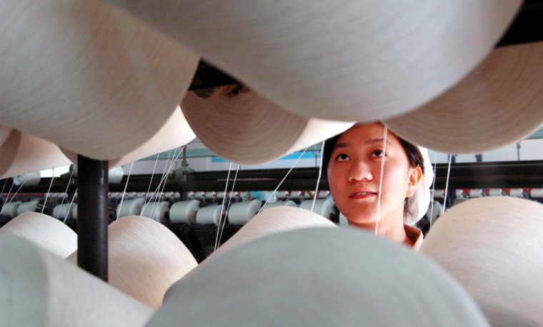 A Chinese worker inspects spools at a textile company in Nantong