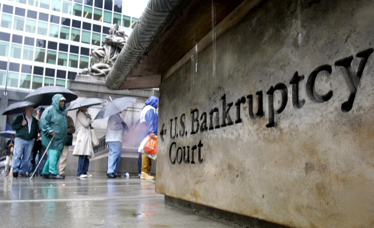 People wait in line under umbrellas against the rain outside U.S. Bankruptcy Court in New York on Friday Oct. 14, 2005 as they tried to beat the start of a new federal law that set stricter standards for seeking protection from creditors. 