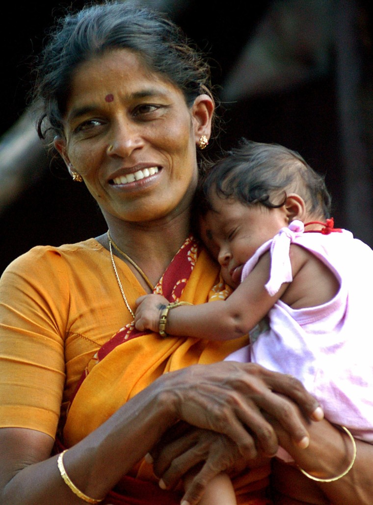 Indian fisherwoman carries her child in the Nagapattinam district