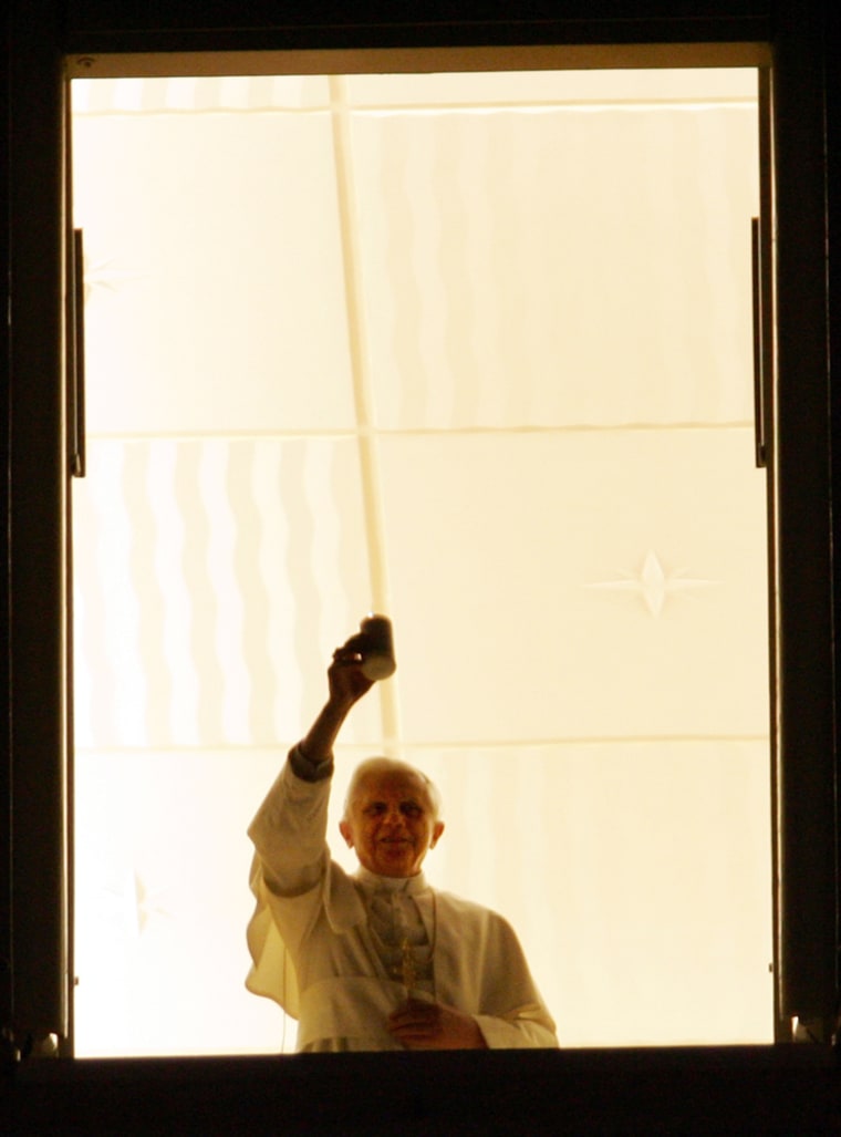 In a Christmas Eve message of peace, Pope Benedict XVI lights a candle at his studio window overlooking St. Peter's square at the Vatican Saturday, Dec. 24, 2005. Pilgrims, tourists and Romans flocked to St. Peter's Square on Saturday before Pope Benedict XVI's first Christmas service since becoming pontiff _ a Midnight Mass that marks the official start of a busy few days of celebrations for the pope. (AP Photo/Andrew Medichini)