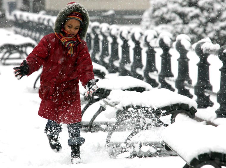 A girl plays in the snow near the Brandenburg Gate in Berlin