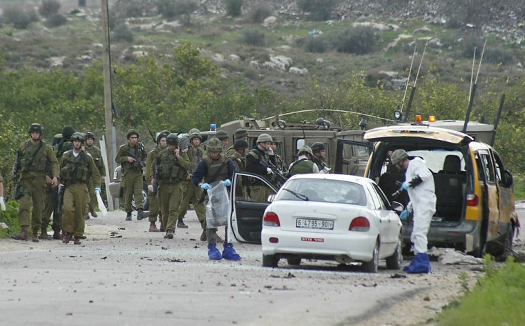 Israeli soldiers examine the scene of an explosion near the West Bank city of Tulkarm
