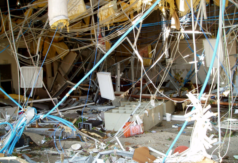 The Gulfport, Miss., office of Sawyer Real Estate lies in ruins after Katrina. One black PC can be seen on the ground, to the left of the toppled bookshelf in the center of the photo. 