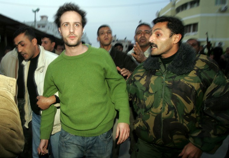 Palestinian security men escort Italian hostage Bernardini after he was released in Gaza Strip