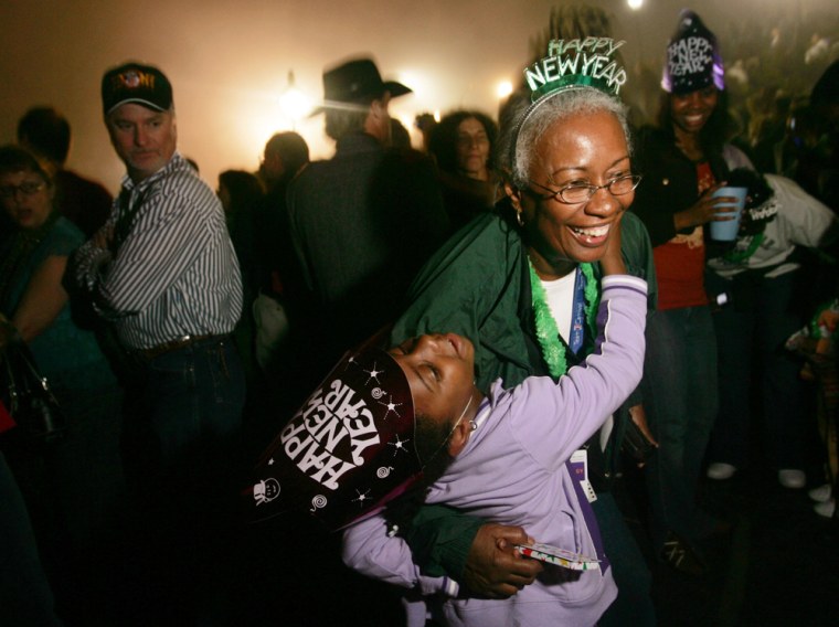 Girl dances with her grandmother during New Year's celebrations in French Quarter of New Orleans