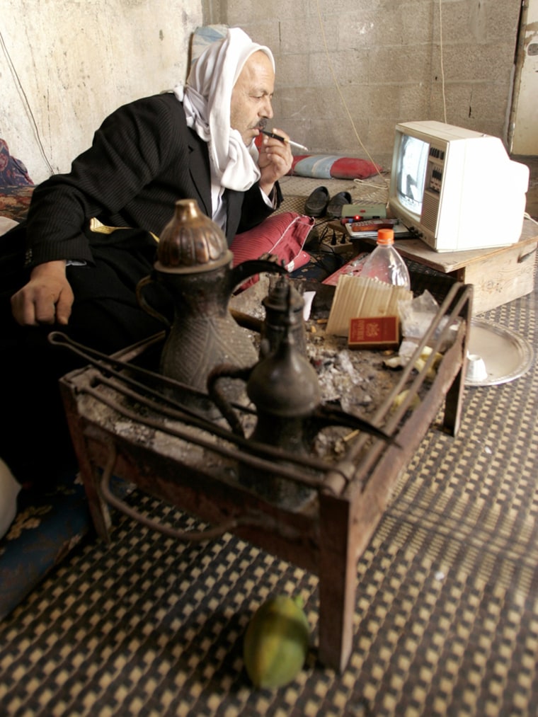 Elderly Palestinian watches television as he follows news of Israeli PM Sharon's health condition in Rafah