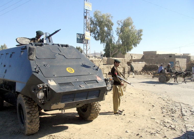 Pakistani paramilitary soldiers with an armoured personal carrier guard a street in Miranshah