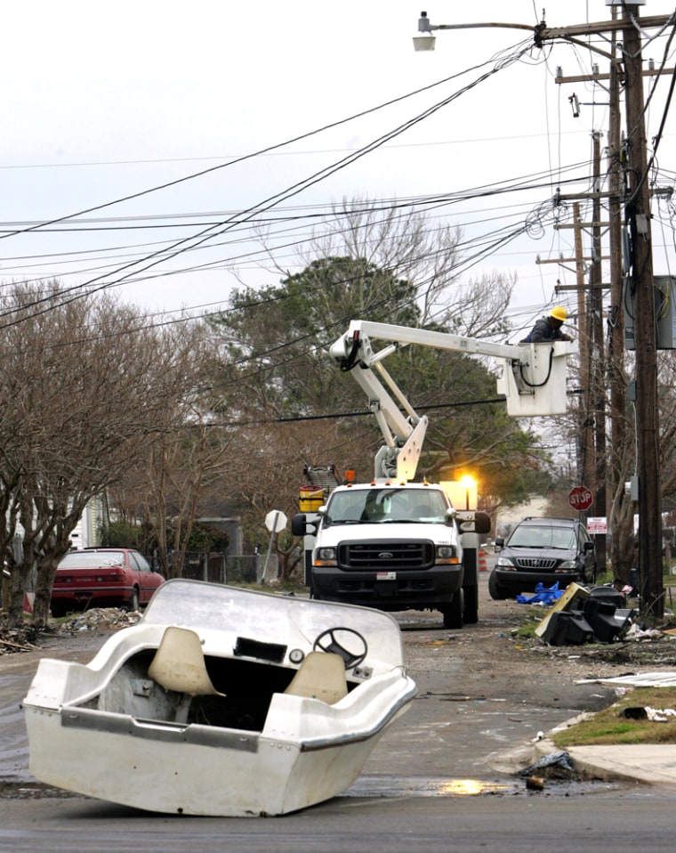 A boat sits in the street of New Orleans as a utility worker repairs lines Tuesday.
