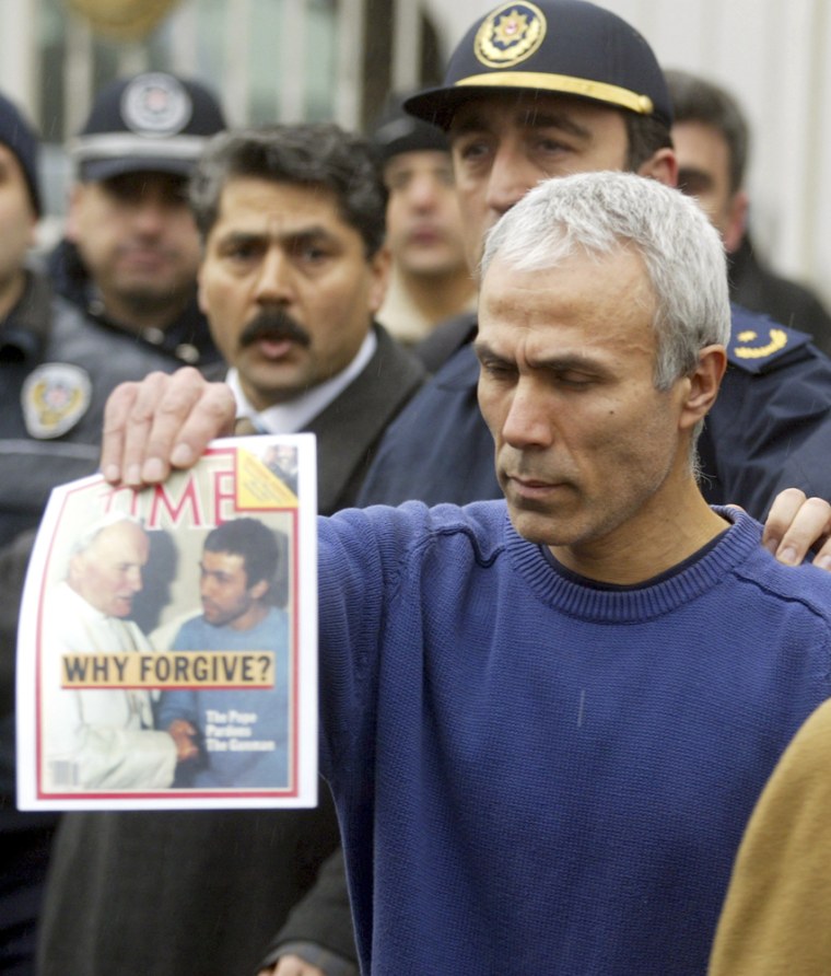 Mehmet Ali Agca, the gunman who shot Pope John Paul II in 1981, holds up an issue of Time magazine outside a military recruitment center after being released from prison in Istanbul on Thursday. Agca served more than 25 years behind bars in Italy and Turkey.