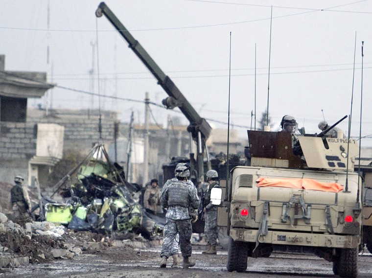 Crane removes wreckage of U.S. OH-58D Kiowa Warrior helicopter in Mosul