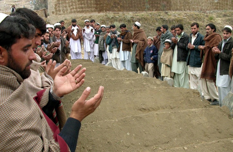 Pakistani tribal villagers offer prayers at graves of people who were killed by U.S. strikes in Damadola on Saturday Jan 14, 2006 in the Pakistani tribal area of Bajour. Pakistani intelligence agents were hunting Wednesday, Jan. 18, 2006  for the graves of four al-Qaida militants believed killed in a U.S. missile strike whose bodies were reportedly whisked away by their comrades who survived, officials said. (AP Photo/Mohammad Zubair)