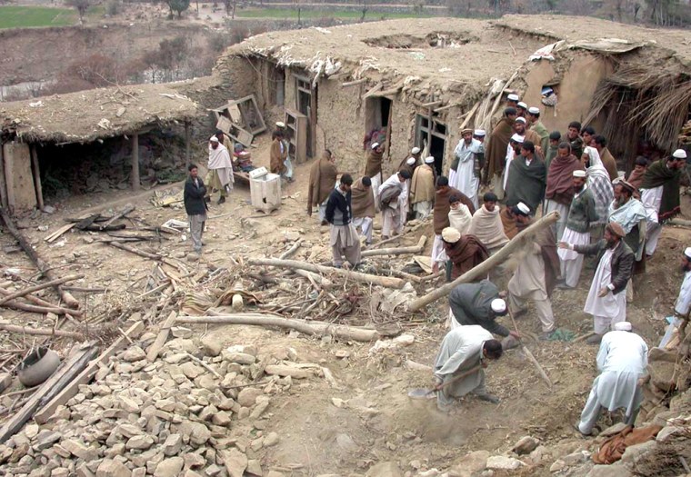 File photo of Pakistani tribesmen searching a house that was destroyed after missile strike in Damadola