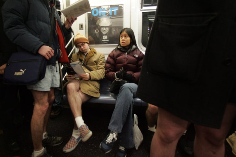A commuter, center, looks at participants in Improv Everywhere's 5th Annual No Pants Subway Ride as they ride the uptown 6 train Sunday in New York City.