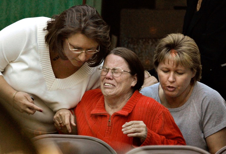 Barbara Mann, center, is consoled at the scene of a three-vehicle crash south of Lake Butler, Fla., where seven children in a car were killed, Wednesday, Jan. 25, 2006. Mann is the adoptive mother of six of the seven children.  The car was driven by 15-year-old Nicki Mann, who was accompanied by her siblings Elizabeth Mann, 15, Johnny Mann, 13, Heaven Mann, 3, Ashley Kenn, 13, Miranda Finn, who was either 8 or 9-years-old, and Anthony Lamb, who was almost two years old. Lamb was in the process of being adopted, said FHP Lt. Mike Burroughs said. (AP Photo/The Gainesville Sun, Tracy Wilcox) **MAGS OUT**