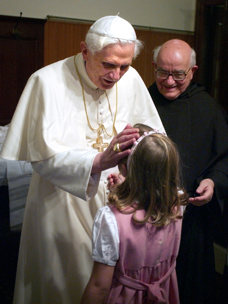 In this photo from the Vatican newspaper L'Osservatore Romano, Pope Benedict XVI talks to a child after he celebrates Mass in St. Ann's parish at the Vatican last Sunday.