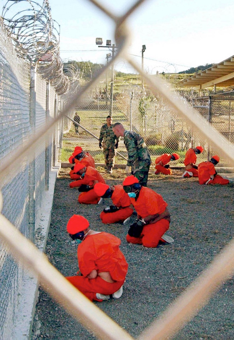 File photo shows detainees sitting in a holding area watched by military police at Camp X-Ray inside Naval Base Guantanamo Bay, Cuba