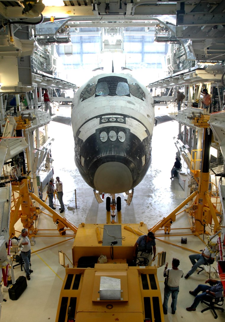 The shuttle Atlantis is surrounded by work platforms in NASA's Orbiter Processing Facility, in a photo from September 2005. NASA says Atlantis will be the first of the three remaining shuttles to be retired.