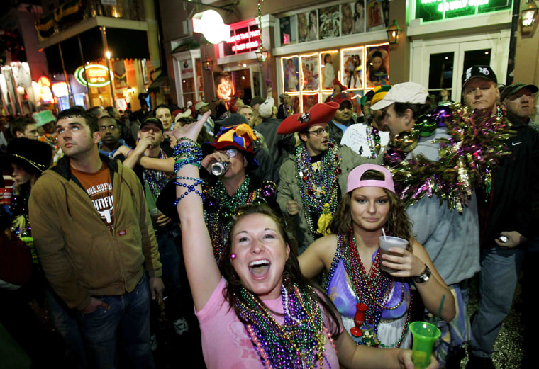 Jennifer Smith of Austin, Texas screams for Mardi Gras beads thrown from a balcony on Bourbon Street in the French Quarter of New Orleans