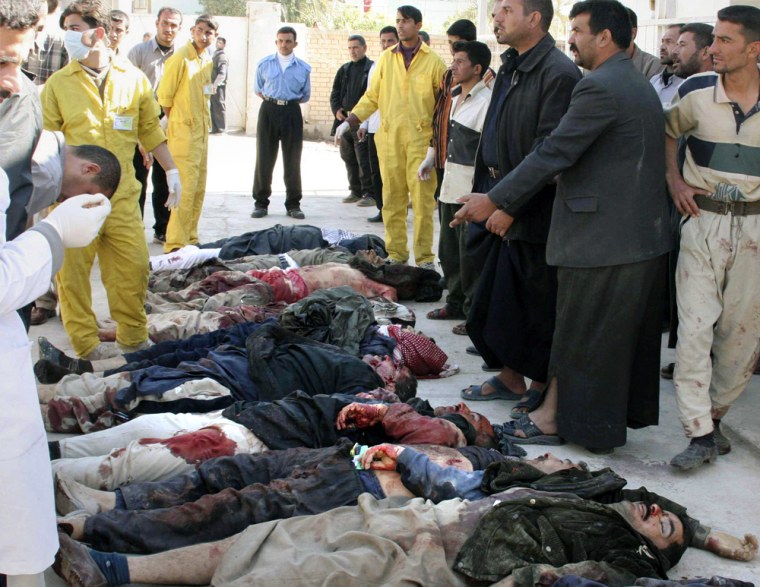 The bodies of 12 Iraqi family members lie on the ground outside a hospital in Baquba,